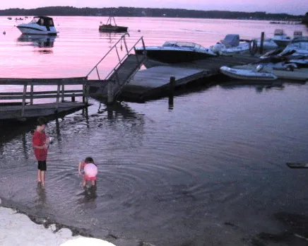 Kids wading by the dock at dusk