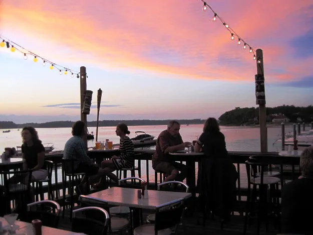 Diners on the deck at sunset