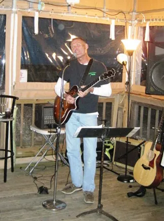 Acoustic guitarist playing at the tiki bar